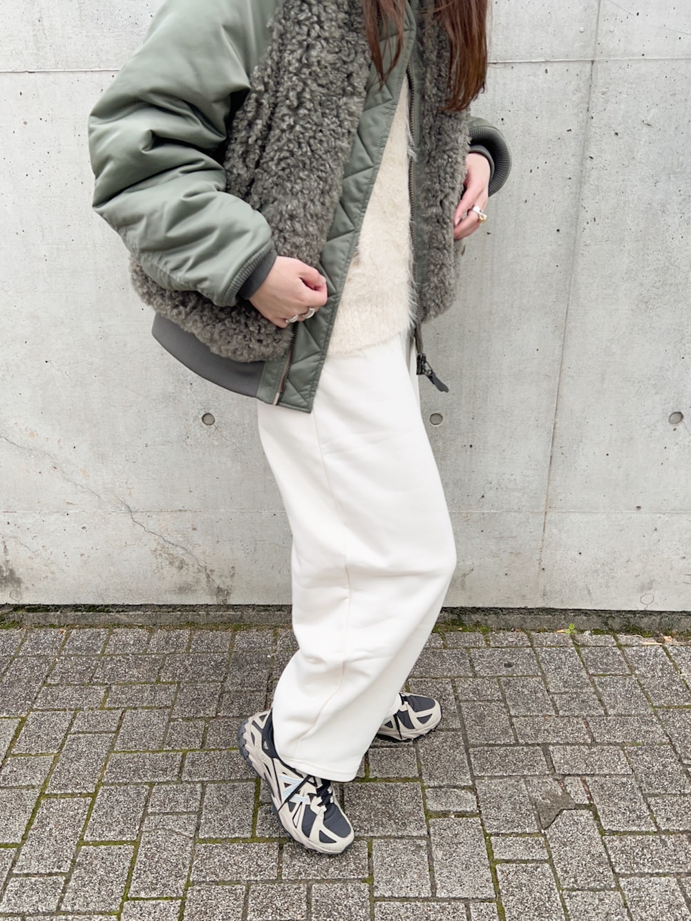 グリーン系のMA-1、ホワイト系のニット/セーター、ホワイト系のスウェットパンツを着用したレディースの冬コーディネートの5枚目の写真