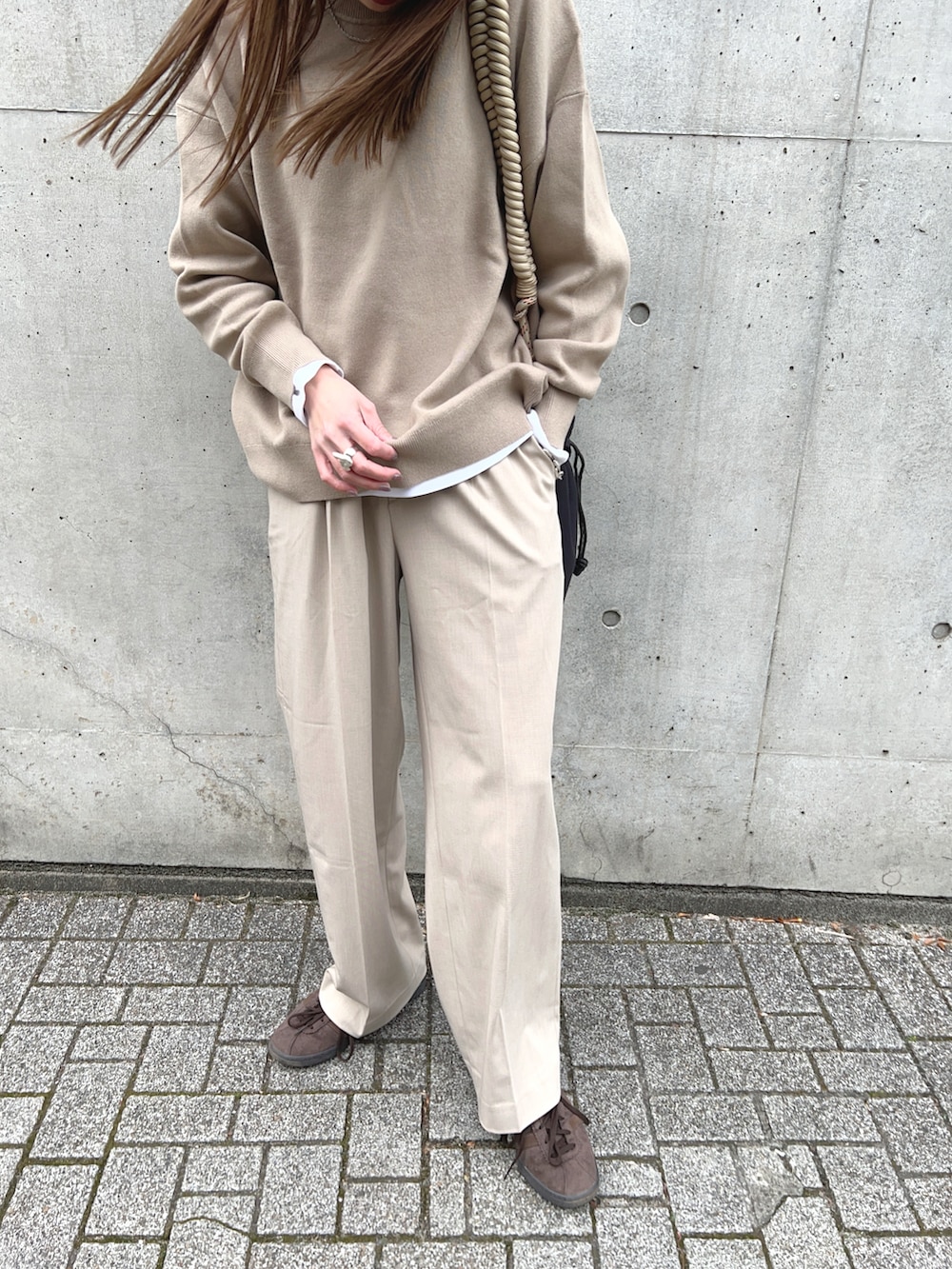 ベージュ系のトップス、ベージュ系のパンツ、ベージュ系のショルダーバッグを着用したレディースの冬コーディネートの5枚目の写真