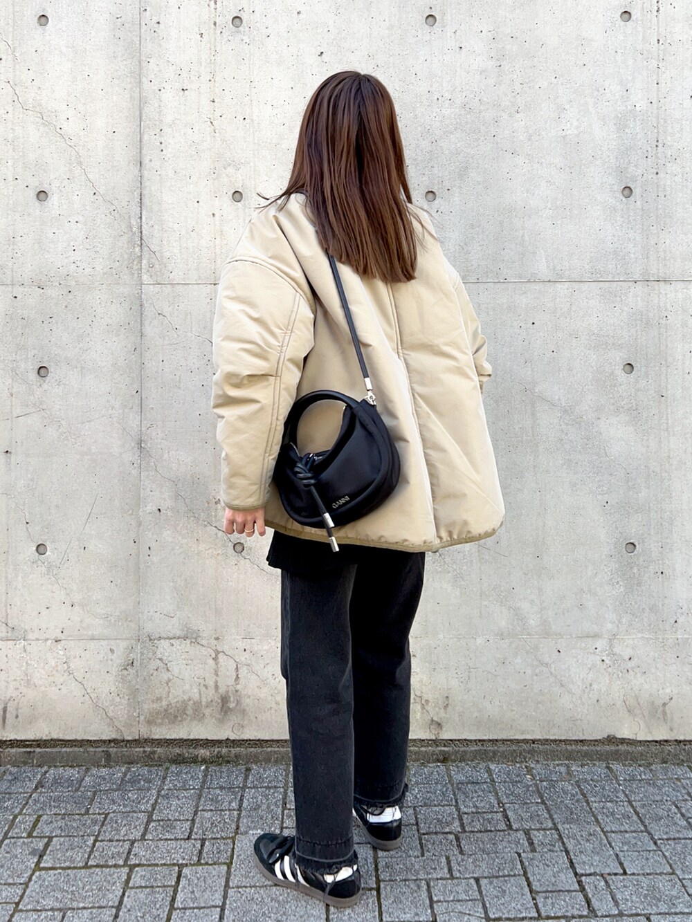 ベージュ系のジャケット/アウター、ホワイト系のTシャツ/カットソー、ブラック系のスラックスを着用したレディースの冬コーディネートの3枚目の写真