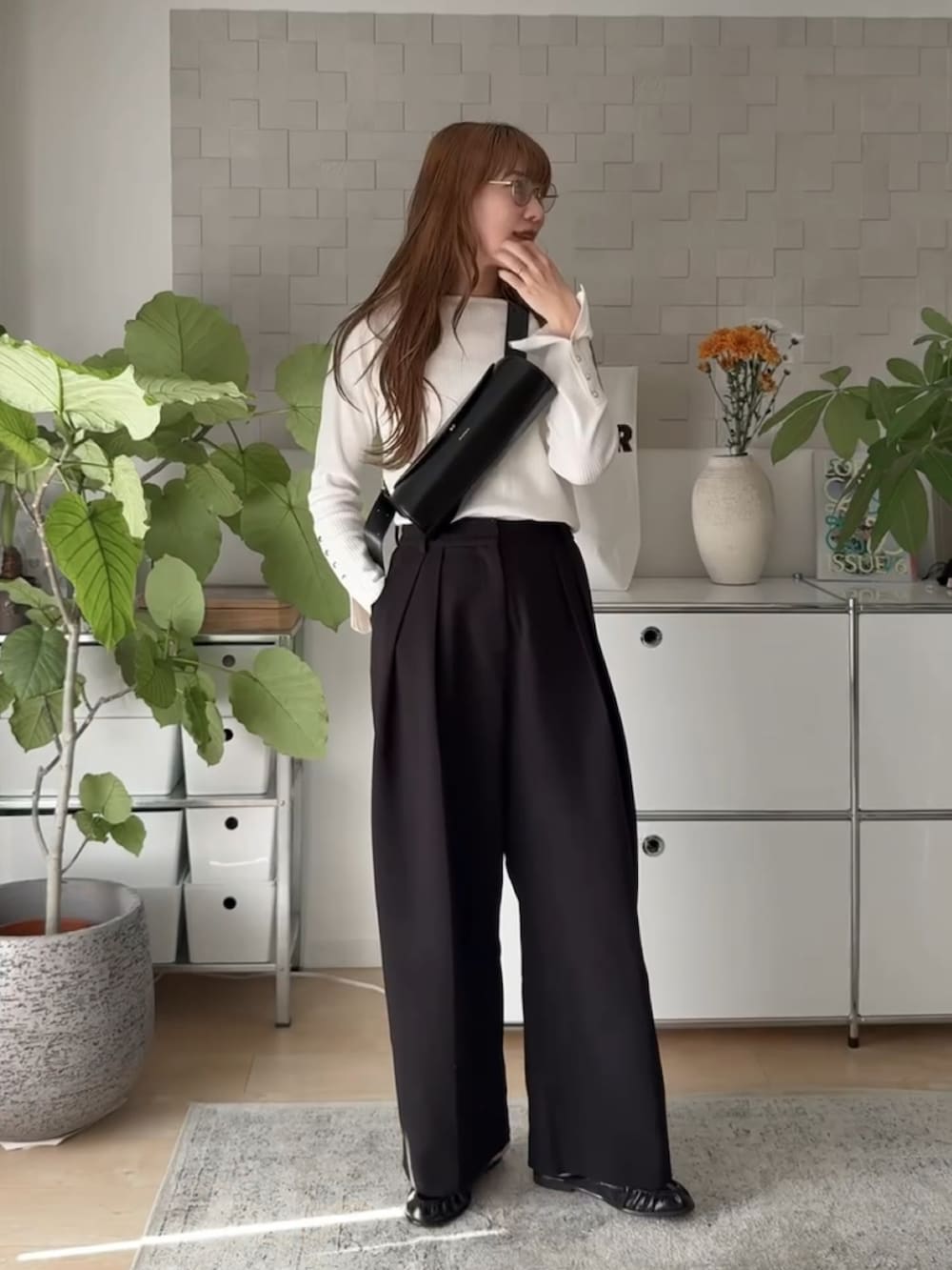 ホワイト系のニット/セーター、ブラック系のその他パンツ、ブラック系のショルダーバッグを着用したレディースの秋コーディネートの2枚目の写真