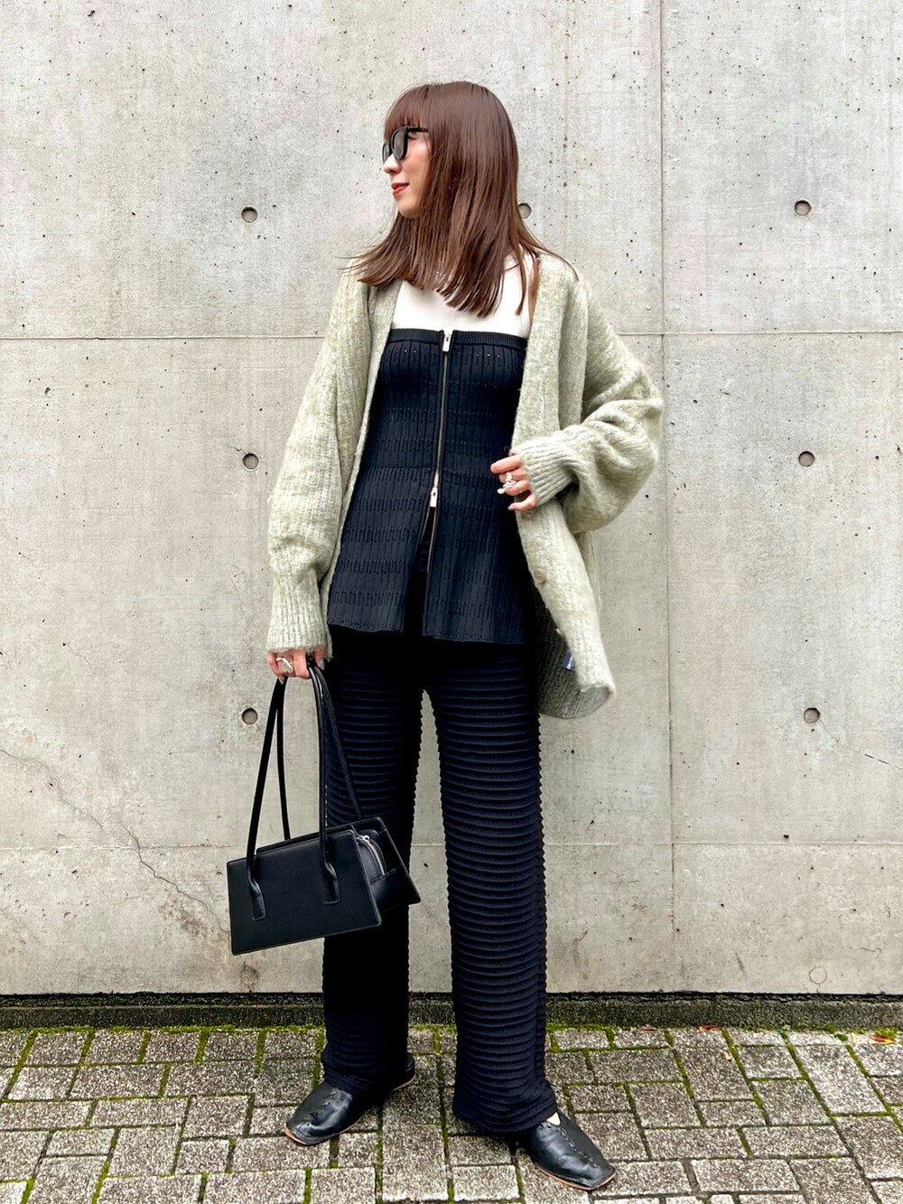 グリーン系のカーディガン/ボレロ、ブラック系のその他パンツ、ブラック系のスラックスを着用したレディースの秋コーディネートの2枚目の写真