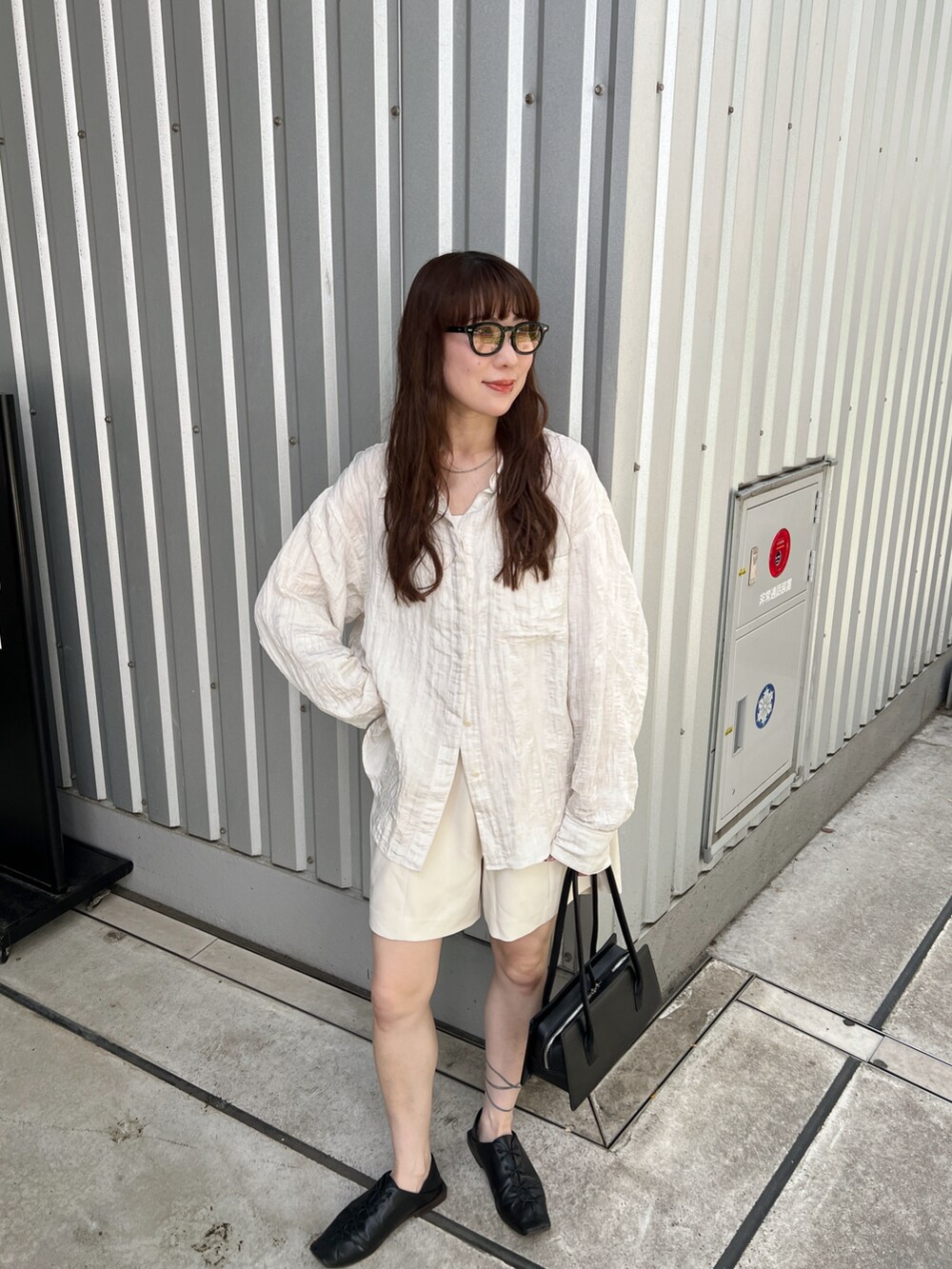ホワイト系のシャツ/ブラウス、ホワイト系のその他パンツ、ブラック系のハンドバッグを着用したレディースの春コーディネートの5枚目の写真