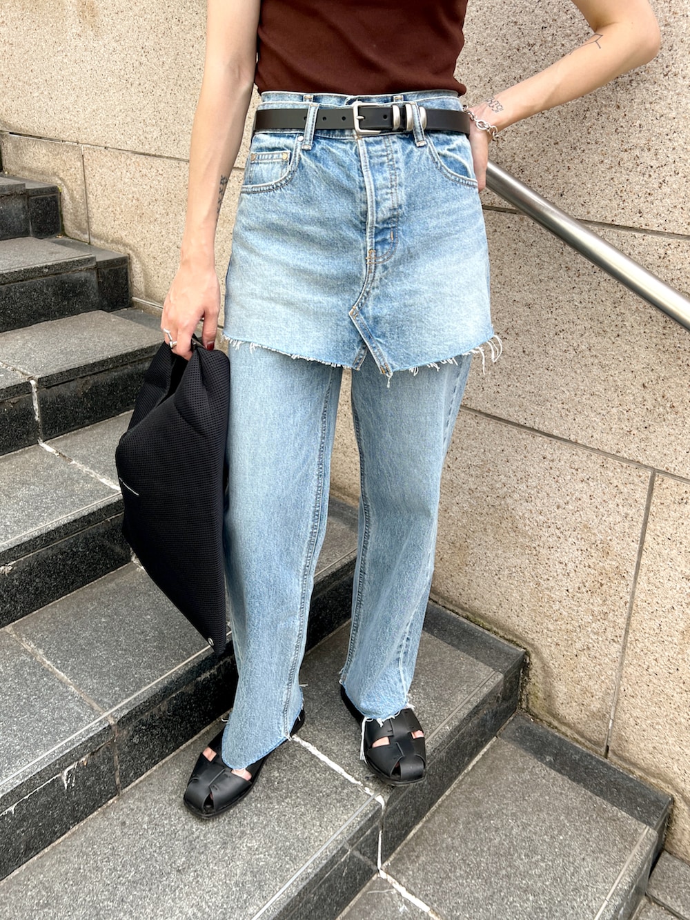 ブルー系のデニムパンツ、ブラック系のショルダーバッグ、ブラウン系のタンクトップを着用したレディースの夏コーディネートの4枚目の写真