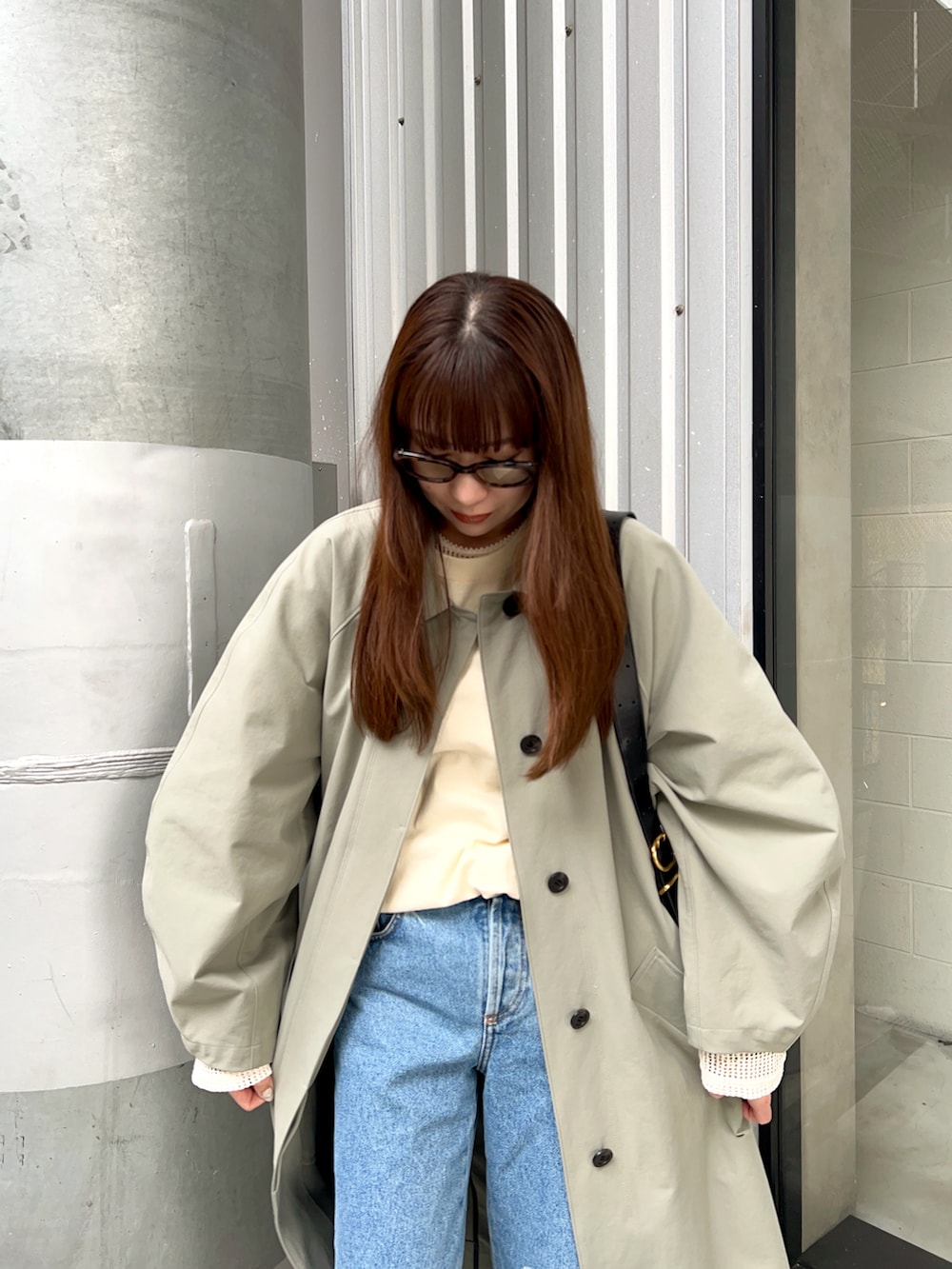 グリーン系のステンカラーコート、ホワイト系のTシャツ/カットソー、ブルー系のデニムパンツを着用したレディースの春コーディネートの4枚目の写真