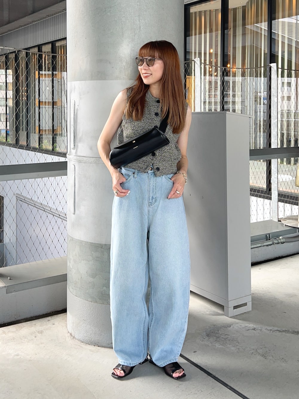 ブラック系のベスト、ブラック系のショルダーバッグ、ブラック系のサンダルを着用したレディースの夏コーディネートの2枚目の写真