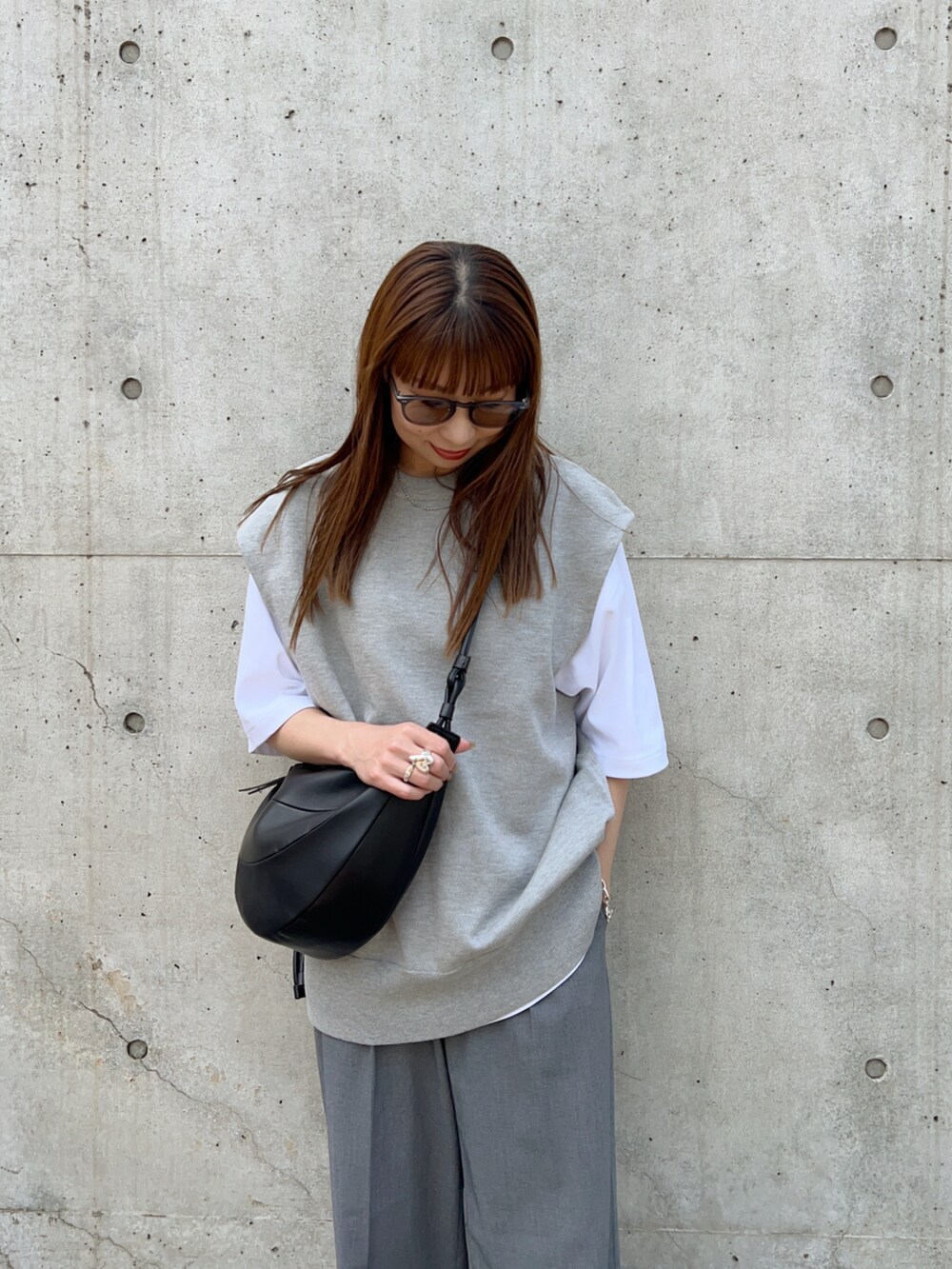 グレー系のニット/セーター、ブラック系のスリッポン、ホワイト系のTシャツ/カットソーを着用したレディースの春コーディネートの4枚目の写真