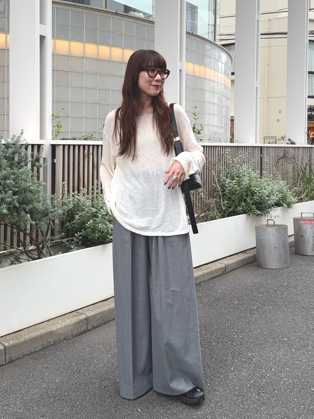 グレー系のその他パンツ、ホワイト系のトップス、ブラック系のバッグを着用したレディースの秋コーディネートの2枚目の写真