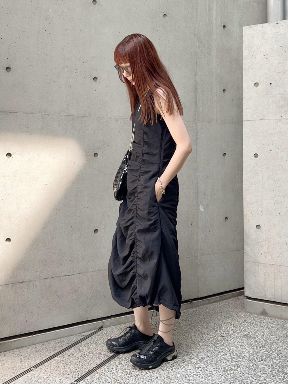 ブラック系のスニーカー、ブラック系のワンピース/ドレス、ブラック系のショルダーバッグを着用したレディースの夏コーディネートの3枚目の写真