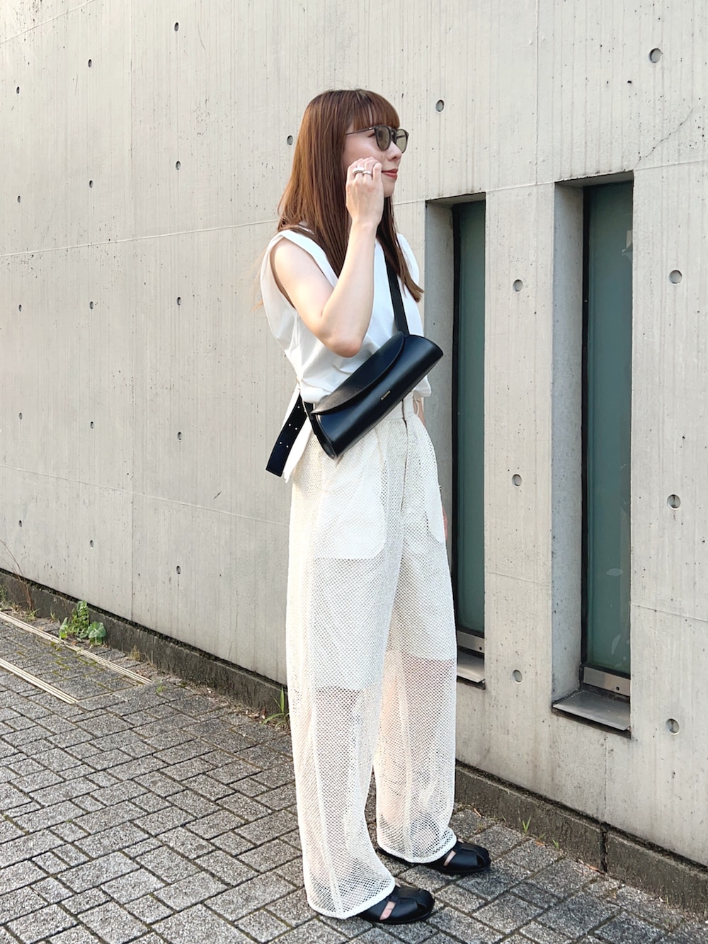 ホワイト系のタンクトップ、ホワイト系のその他パンツ、ブラック系のショルダーバッグを着用したレディースの夏コーディネートの3枚目の写真