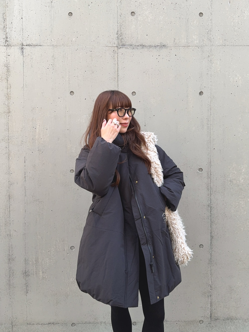 ブラック系のダウンジャケット/コート、ベージュ系のショルダーバッグ、グレー系のスニーカーを着用したレディースの冬コーディネートの4枚目の写真