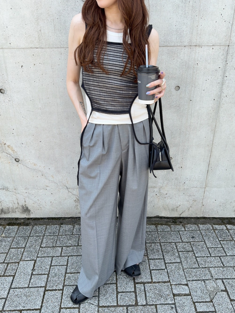 ブラック系のタンクトップ、グレー系のその他パンツ、ブラック系のサンダルを着用したレディースの夏コーディネートの5枚目の写真