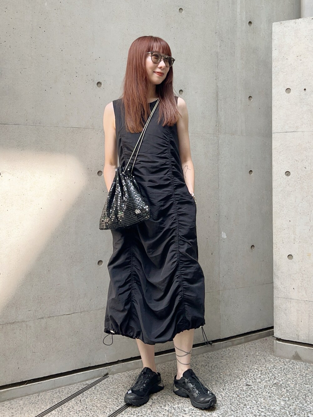 ブラック系のスニーカー、ブラック系のワンピース/ドレス、ブラック系のショルダーバッグを着用したレディースの夏コーディネートの2枚目の写真