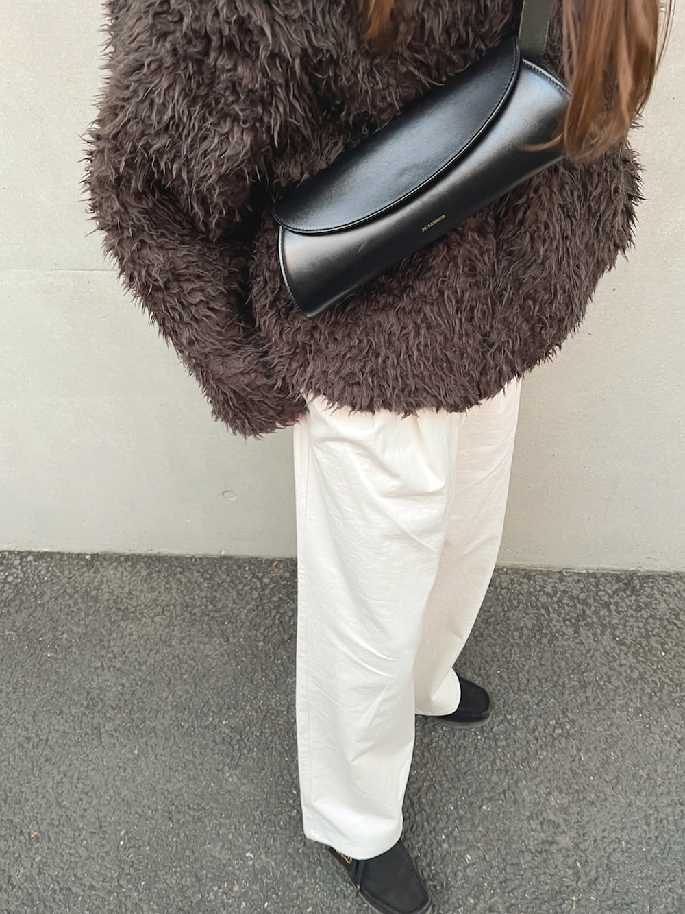 ブラウン系のブルゾン、ホワイト系のチノパンツ、ブラック系のショルダーバッグを着用したレディースの冬コーディネートの5枚目の写真