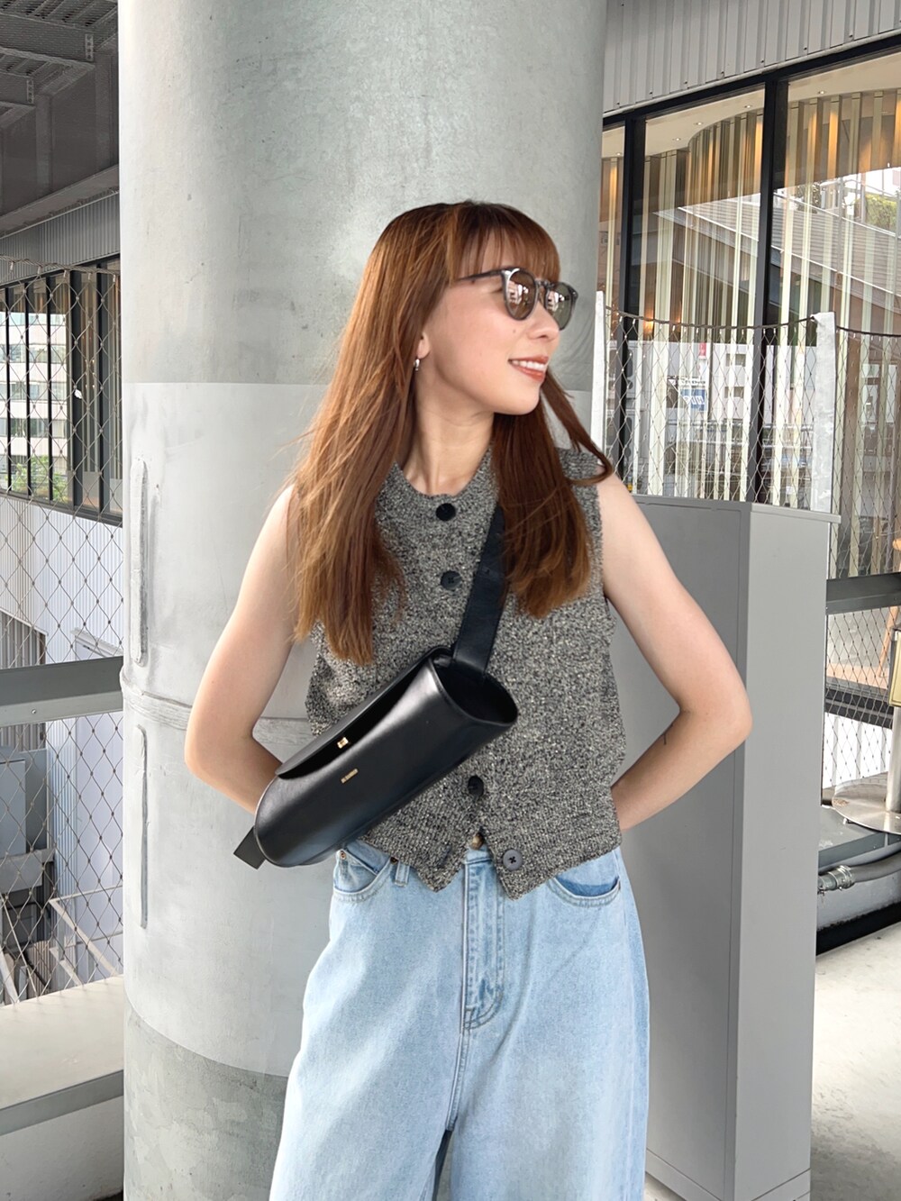 ブラック系のベスト、ブラック系のショルダーバッグ、ブラック系のサンダルを着用したレディースの夏コーディネートの3枚目の写真