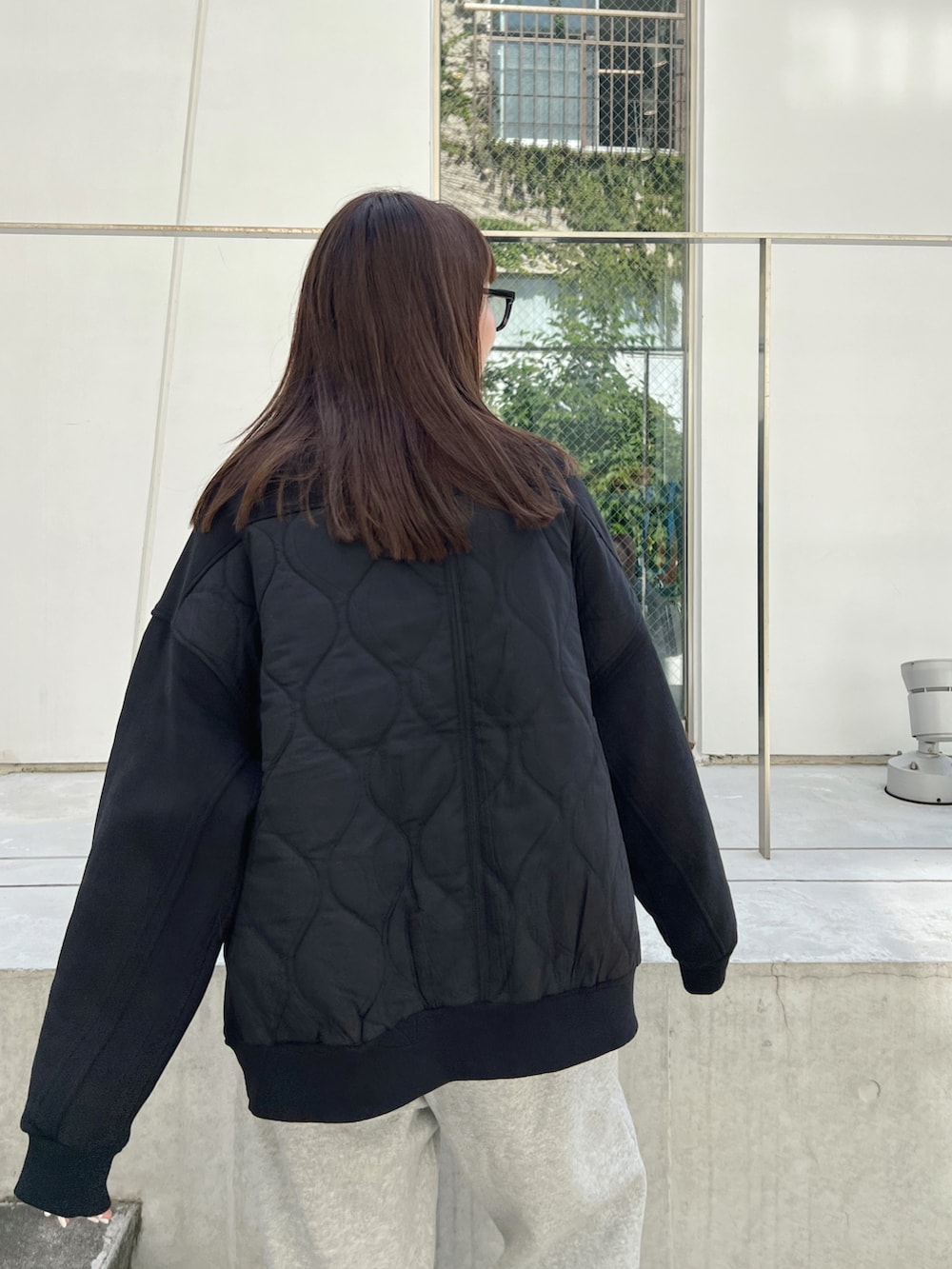 ブラック系のブルゾン、グレー系のスウェットパンツ、ブラック系のハンドバッグを着用したレディースの秋コーディネートの5枚目の写真
