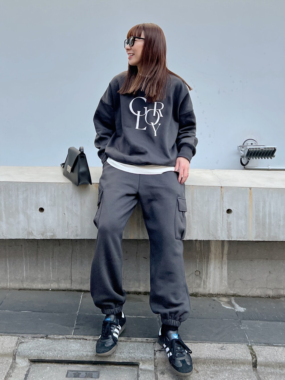 ブラック系のショルダーバッグ、グレー系のスウェット、グレー系のカーゴパンツを着用したレディースの冬コーディネートの2枚目の写真