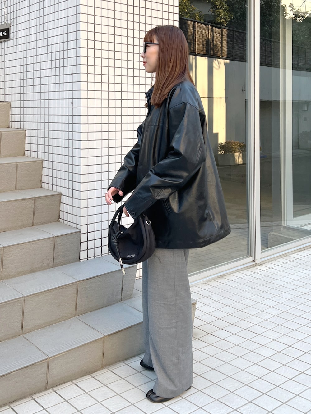 ブラック系のニット/セーター、ブラック系のその他アウター、グレー系のスラックスを着用したレディースの冬コーディネートの3枚目の写真