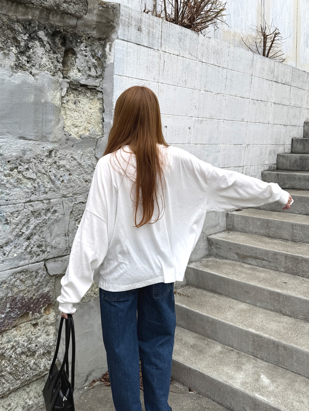 ホワイト系のTシャツ/カットソー、ブラック系のスリッポン、ブラック系のバッグを着用したレディースの春コーディネートの4枚目の写真