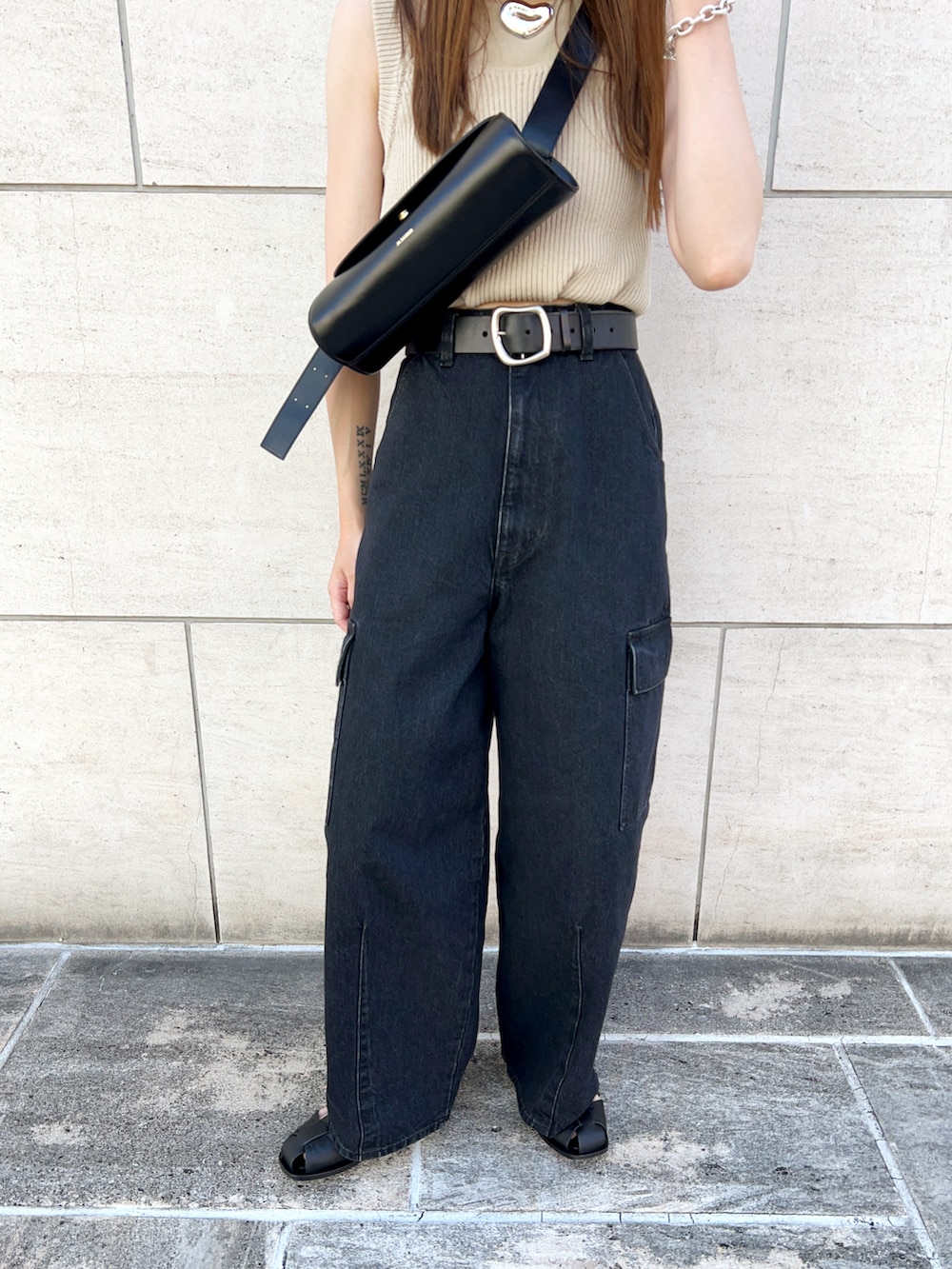 ベージュ系のニット/セーター、グレー系のデニムパンツ、ブラック系のショルダーバッグを着用したレディースの夏コーディネートの5枚目の写真