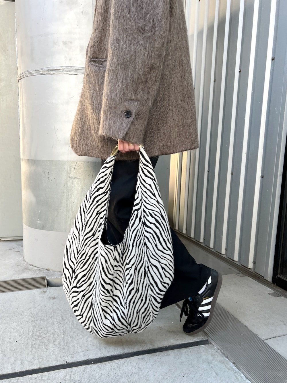 グレー系のテーラードジャケット、ブラック系のベスト、その他のトートバッグを着用したレディースの冬コーディネートの4枚目の写真