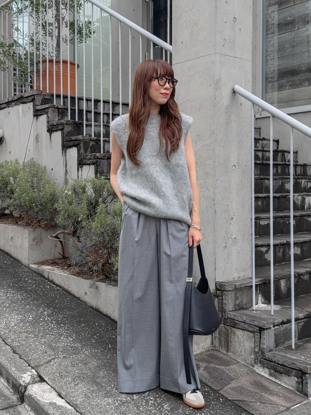 グレー系のベスト、グレー系のその他パンツ、ホワイト系のスニーカーを着用したレディースの秋コーディネートの2枚目の写真