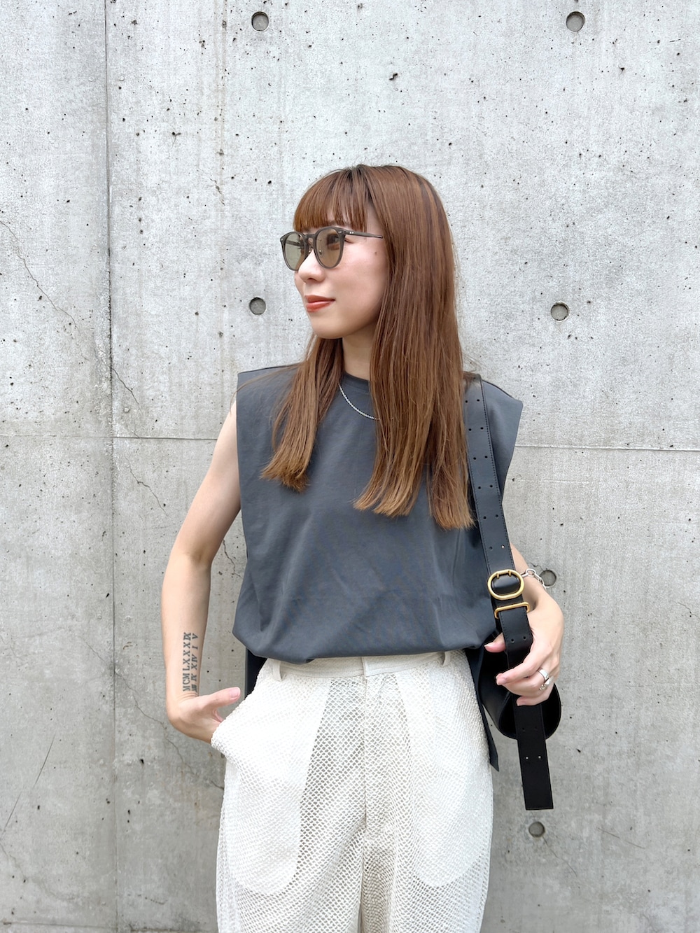 グレー系のタンクトップ、ホワイト系のその他パンツ、ブラック系のショルダーバッグを着用したレディースの夏コーディネートの4枚目の写真