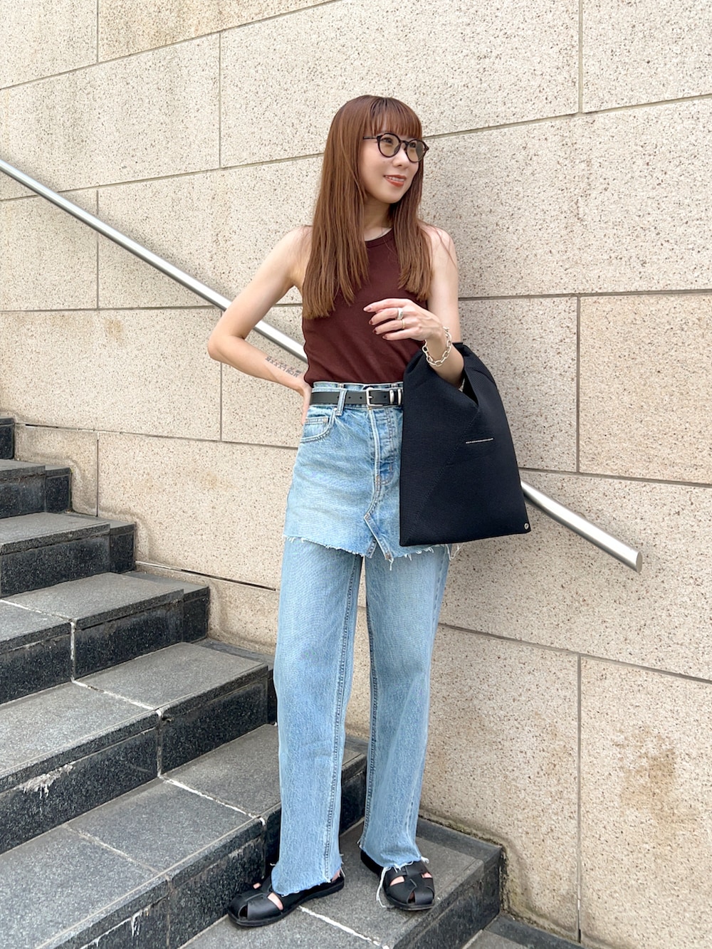ブルー系のデニムパンツ、ブラック系のショルダーバッグ、ブラウン系のタンクトップを着用したレディースの夏コーディネートの2枚目の写真