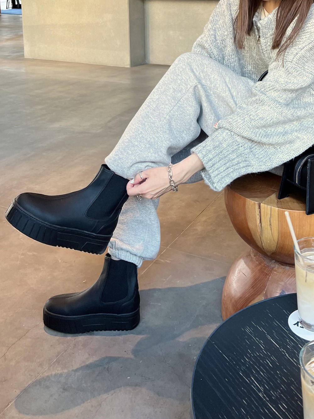 ブラック系のブーツ、グレー系のニット/セーター、グレー系のスウェットパンツを着用したレディースの秋コーディネートの3枚目の写真