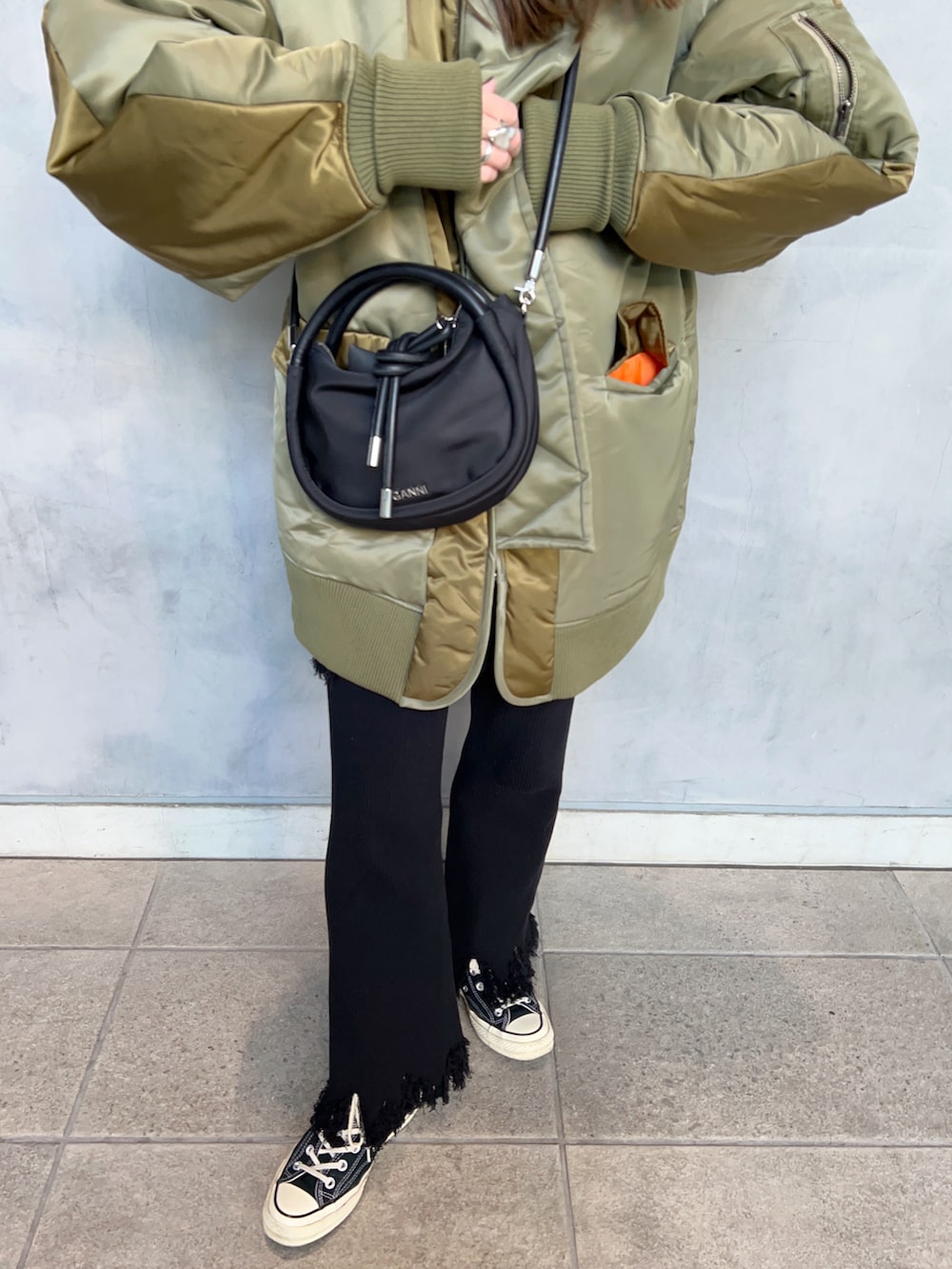 グリーン系のブルゾン、ブラック系のハンドバッグ、ブラック系のその他パンツを着用したレディースの春コーディネートの5枚目の写真
