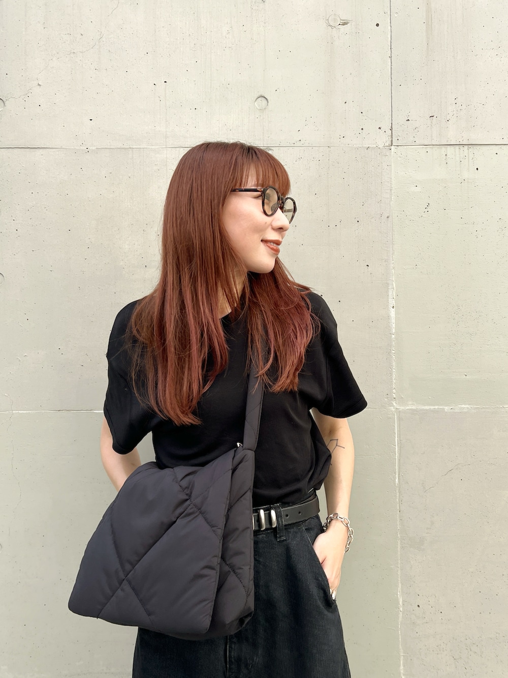 ブラック系のTシャツ/カットソー、グレー系のデニムパンツ、ベージュ系のスニーカーを着用したレディースの秋コーディネートの2枚目の写真