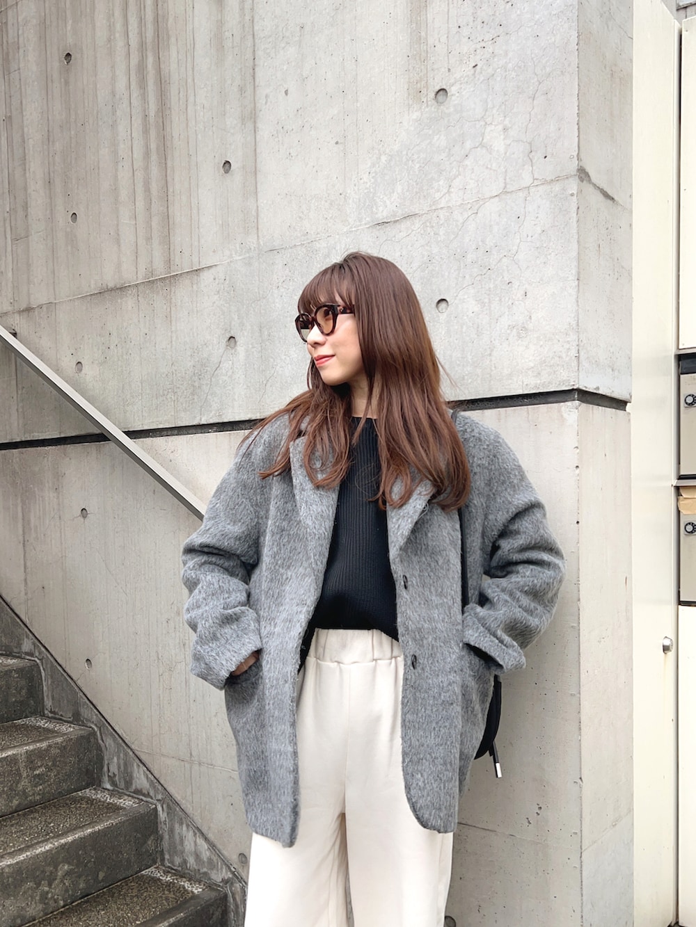 グレー系のテーラードジャケット、ホワイト系のスウェットパンツ、ブラック系のショルダーバッグを着用したレディースの冬コーディネートの4枚目の写真
