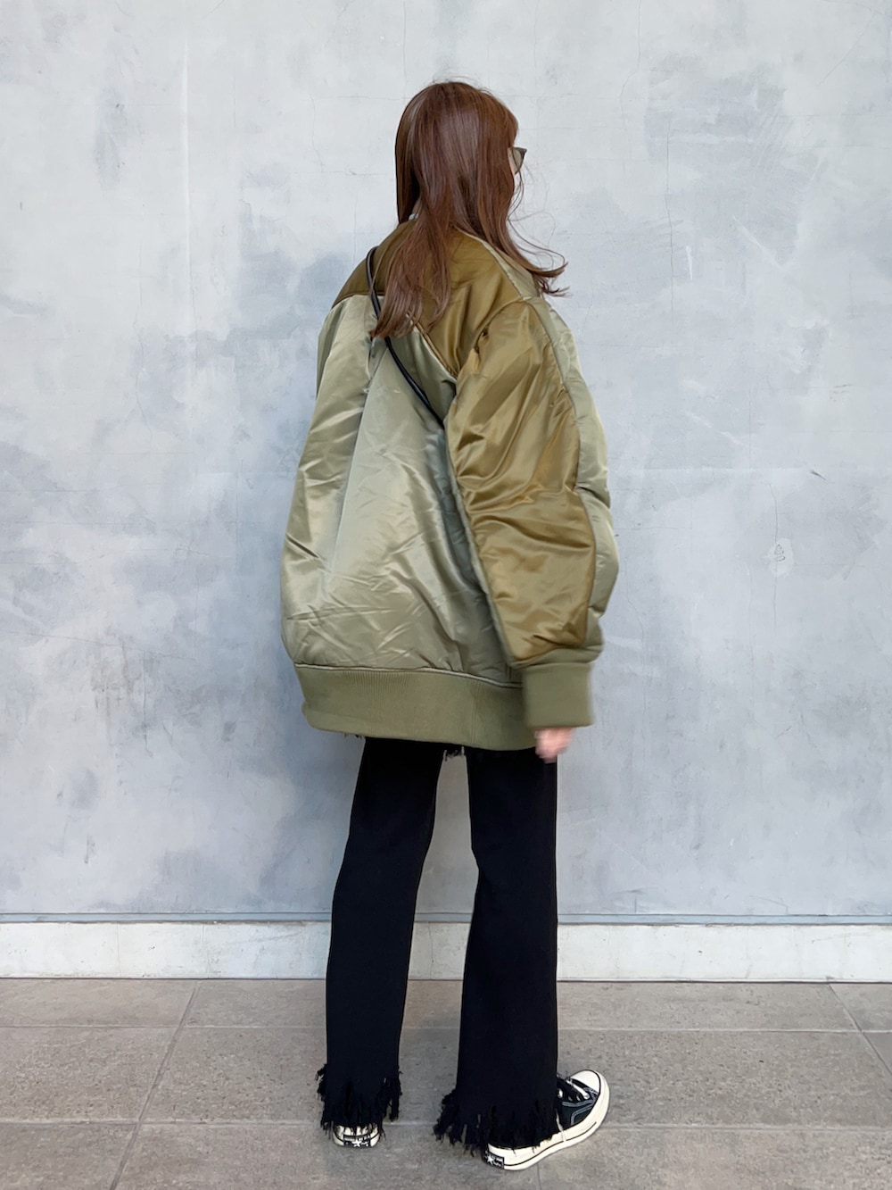 グリーン系のブルゾン、ブラック系のハンドバッグ、ブラック系のその他パンツを着用したレディースの春コーディネートの3枚目の写真