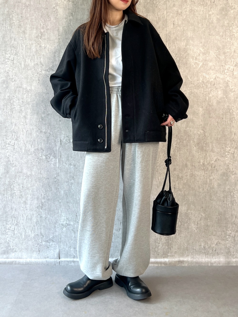 ブラック系のその他アウター、ホワイト系のTシャツ/カットソー、グレー系のスウェットパンツを着用したレディースの冬コーディネートの4枚目の写真