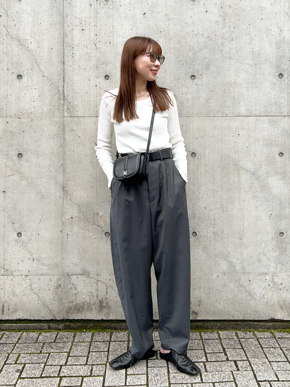 ホワイト系のTシャツ/カットソー、グレー系のその他パンツ、ブラック系のスリッポンを着用したレディースの春コーディネートの2枚目の写真