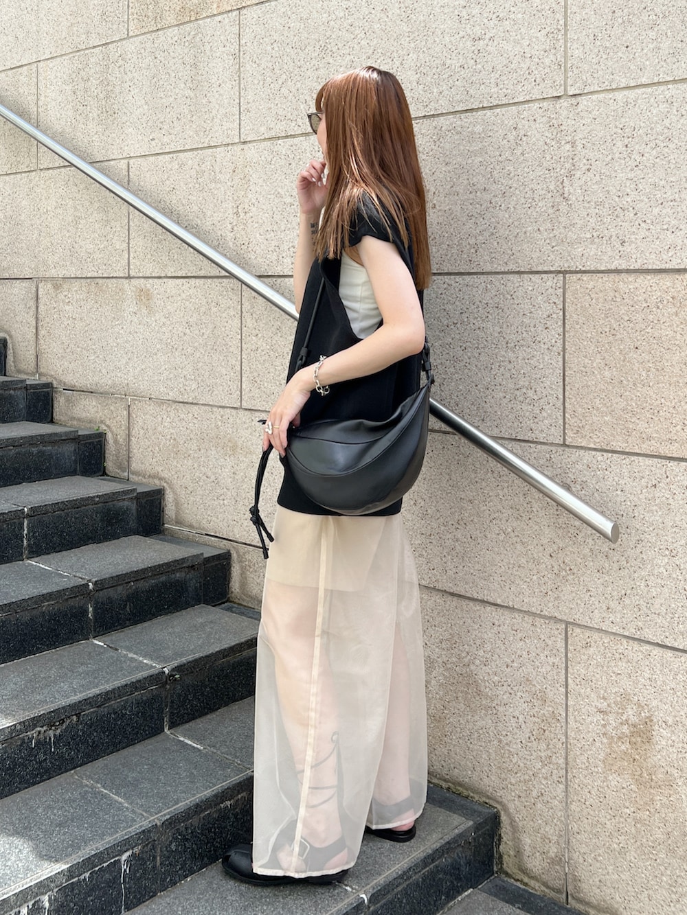 ブラック系のニット/セーター、ベージュ系のその他パンツ、ブラック系のサンダルを着用したレディースの夏コーディネートの3枚目の写真