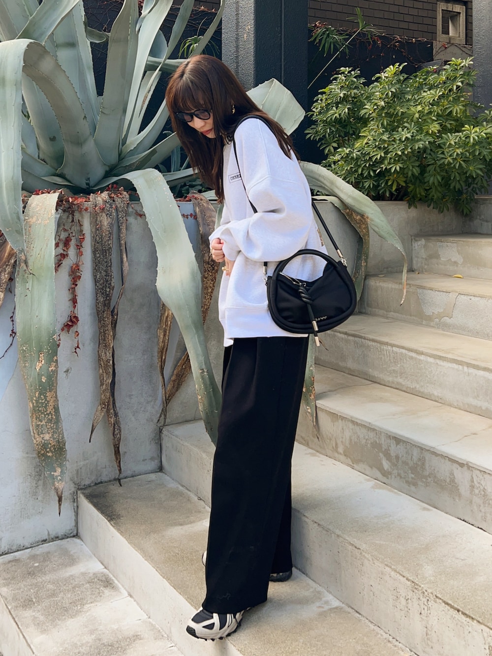 ブラック系のその他パンツ、グレー系のスウェット、ブラック系のショルダーバッグを着用したレディースの冬コーディネートの3枚目の写真