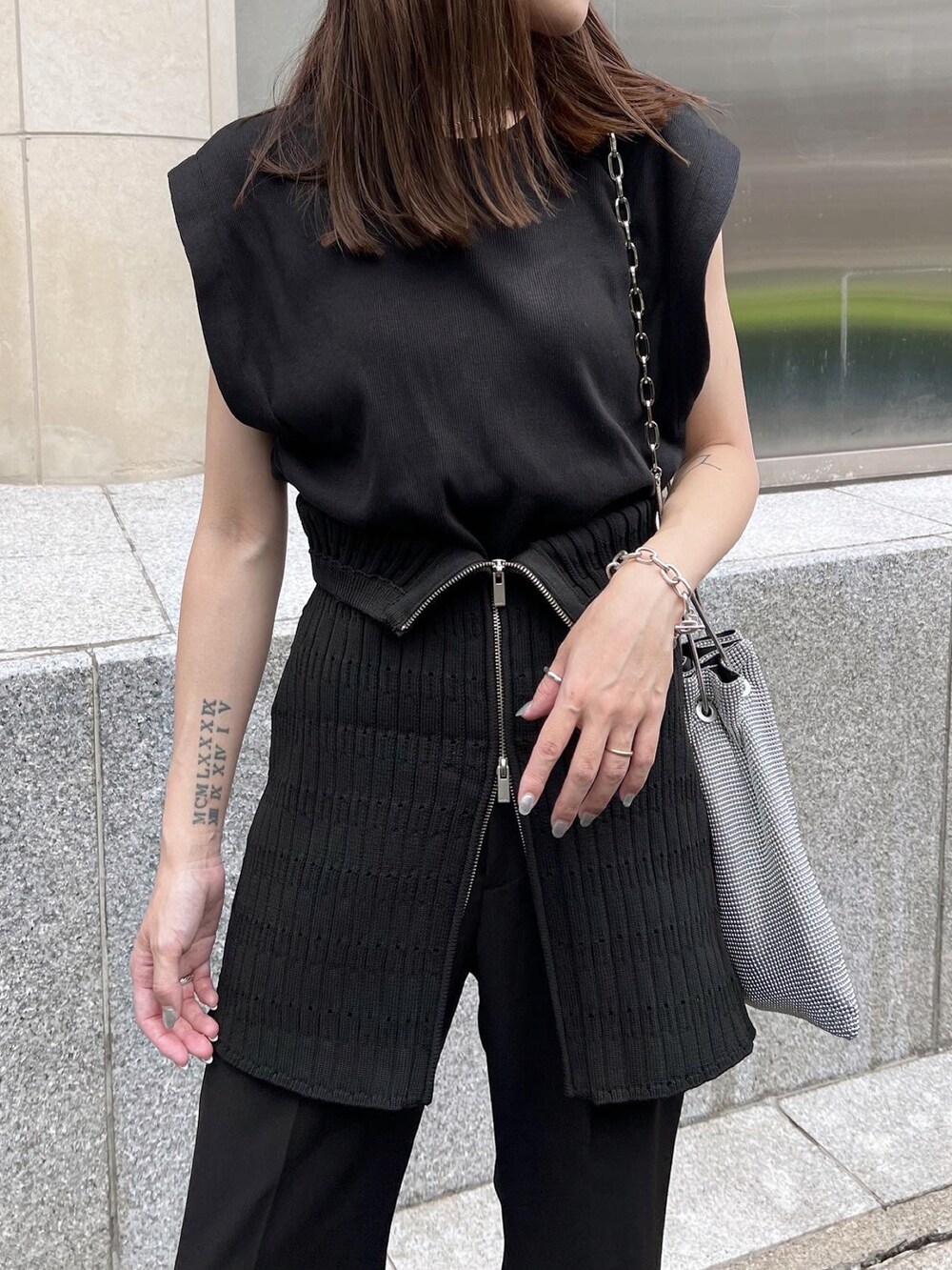 ブラック系のTシャツ/カットソー、ブラック系のスラックス、ブラック系のブーツを着用したレディースの秋コーディネートの3枚目の写真