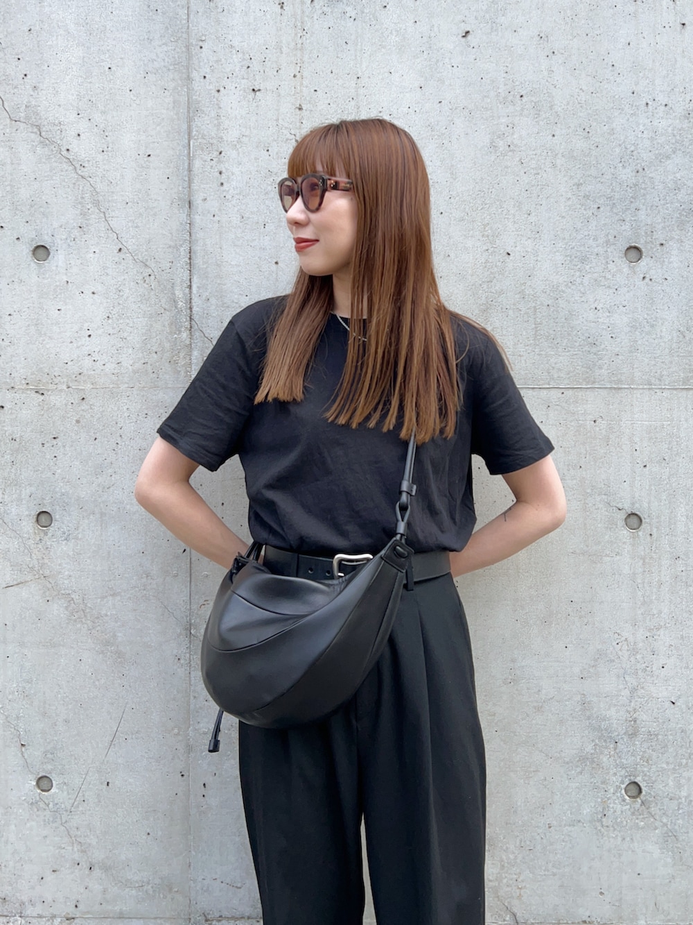 ブラック系のTシャツ/カットソー、ブラック系のスリッポン、ブラック系のパンツを着用したレディースの春コーディネートの3枚目の写真