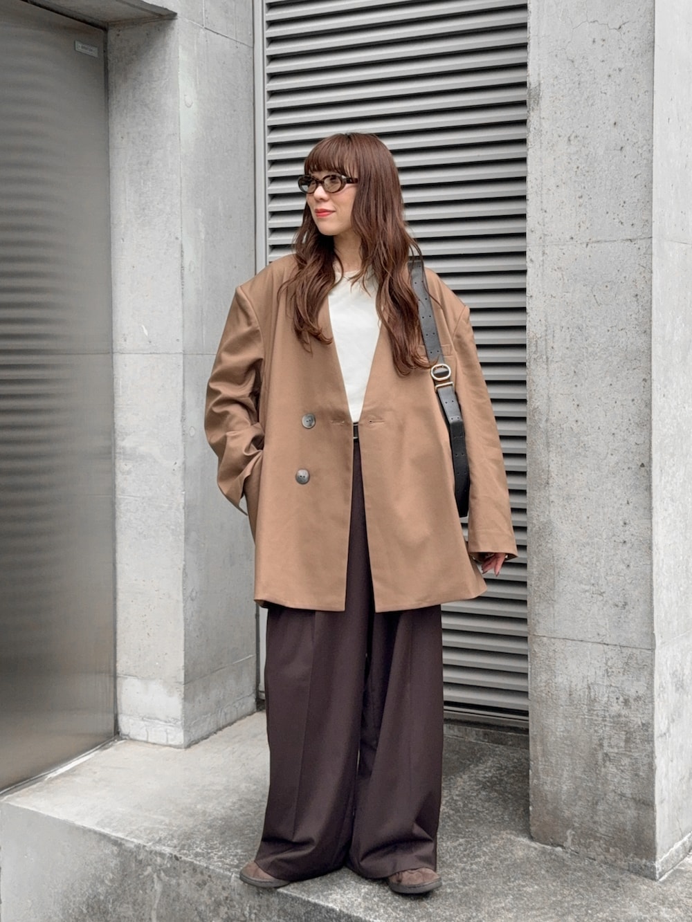 ブラウン系のその他アウター、ブラウン系のその他パンツ、ホワイト系のTシャツ/カットソーを着用したレディースの秋コーディネートの2枚目の写真