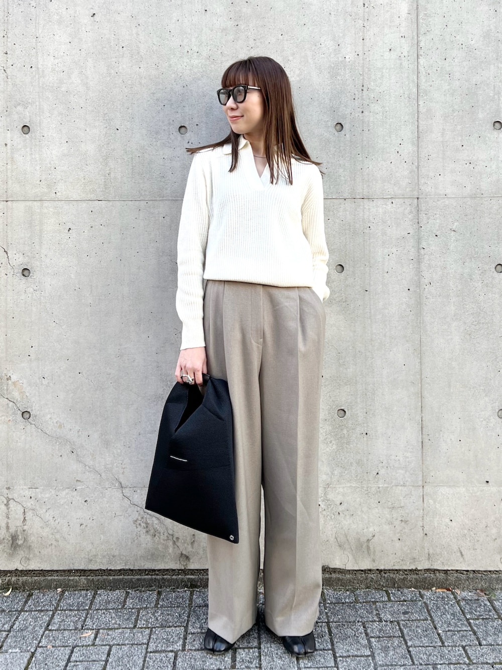 ブラック系のピーコート、ホワイト系のニット/セーター、ベージュ系のその他パンツを着用したレディースの冬コーディネートの3枚目の写真