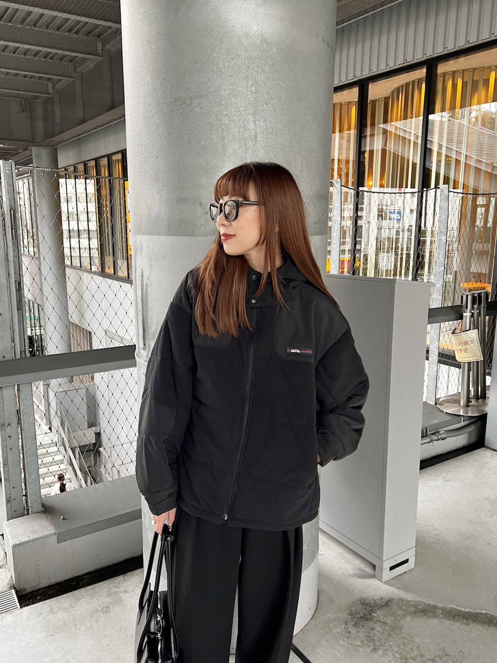 ブラック系のブルゾン、ブラック系のその他パンツ、ホワイト系のTシャツ/カットソーを着用したレディースの冬コーディネートの3枚目の写真