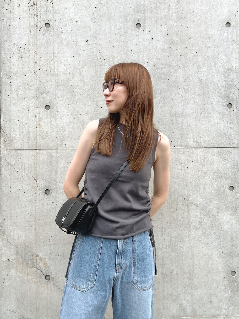 ブラック系のサンダル、グレー系のトップス、ブルー系のデニムパンツを着用したレディースの夏コーディネートの4枚目の写真