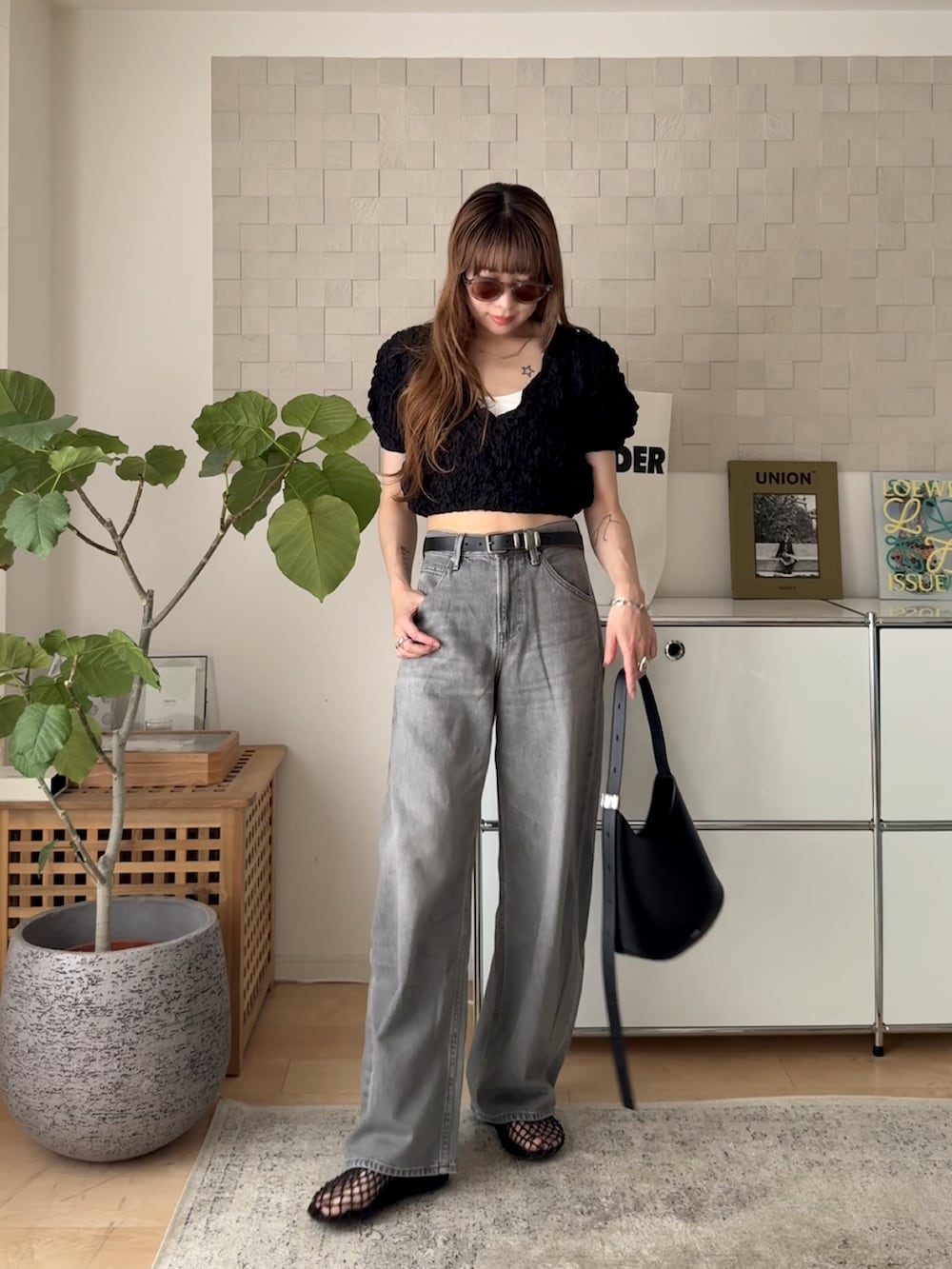 ブラック系のTシャツ/カットソー、ブラック系のサンダル、グレー系のデニムパンツを着用したレディースの夏コーディネートの2枚目の写真