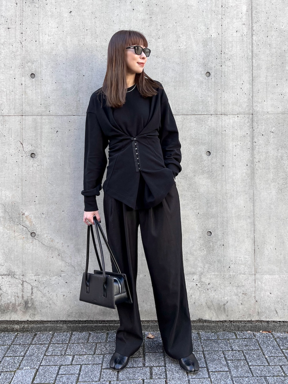 グリーン系のブルゾン、ブラック系のスラックス、ブラック系のハンドバッグを着用したレディースの冬コーディネートの4枚目の写真