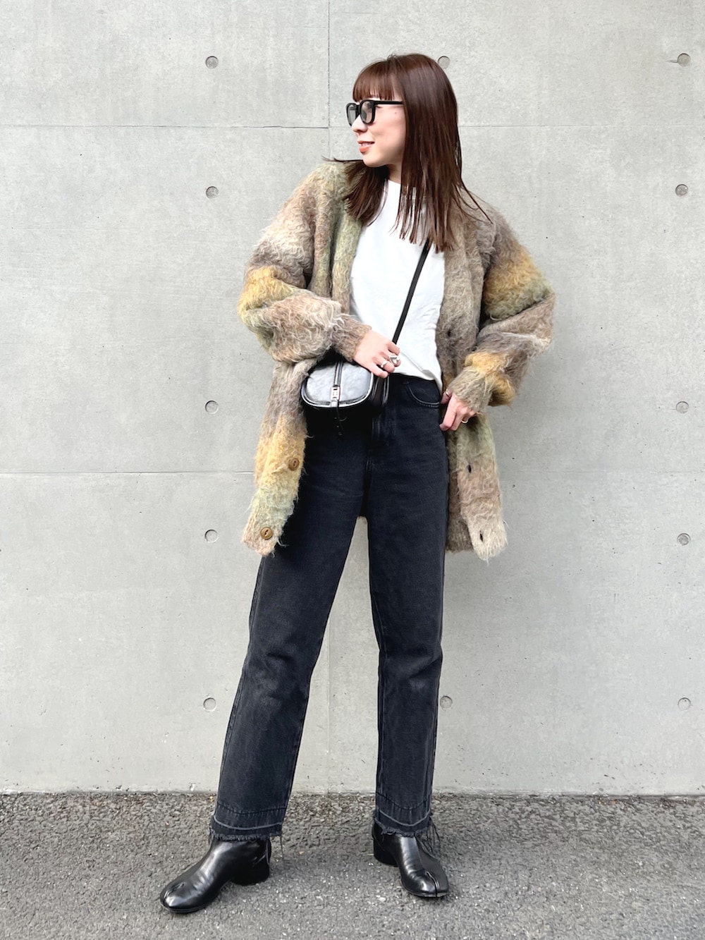 ベージュ系のカーディガン/ボレロ、ホワイト系のTシャツ/カットソー、ブラック系のショルダーバッグを着用したレディースの秋コーディネートの2枚目の写真