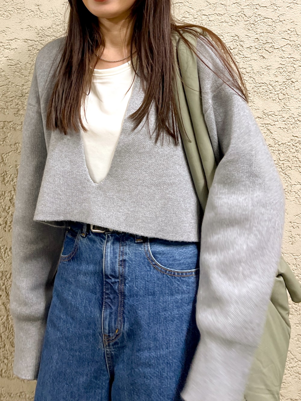 グレー系のニット/セーター、ブルー系のデニムパンツ、ブラック系のブーツを着用したレディースの冬コーディネートの4枚目の写真