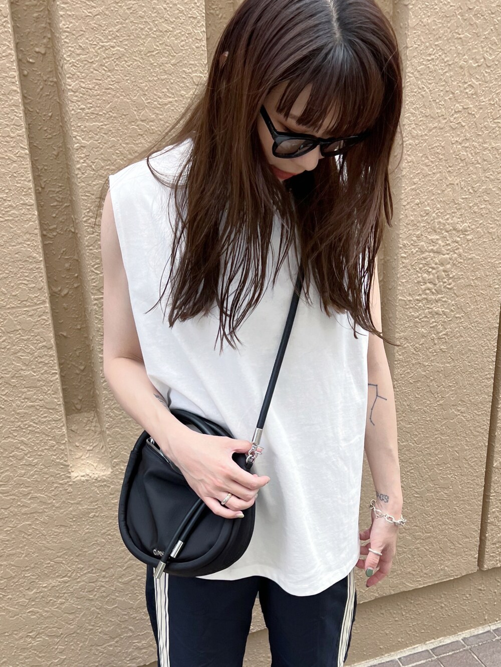 ブラック系のスニーカー、ブラック系のその他パンツ、ホワイト系のTシャツ/カットソーを着用したレディースの夏コーディネートの3枚目の写真