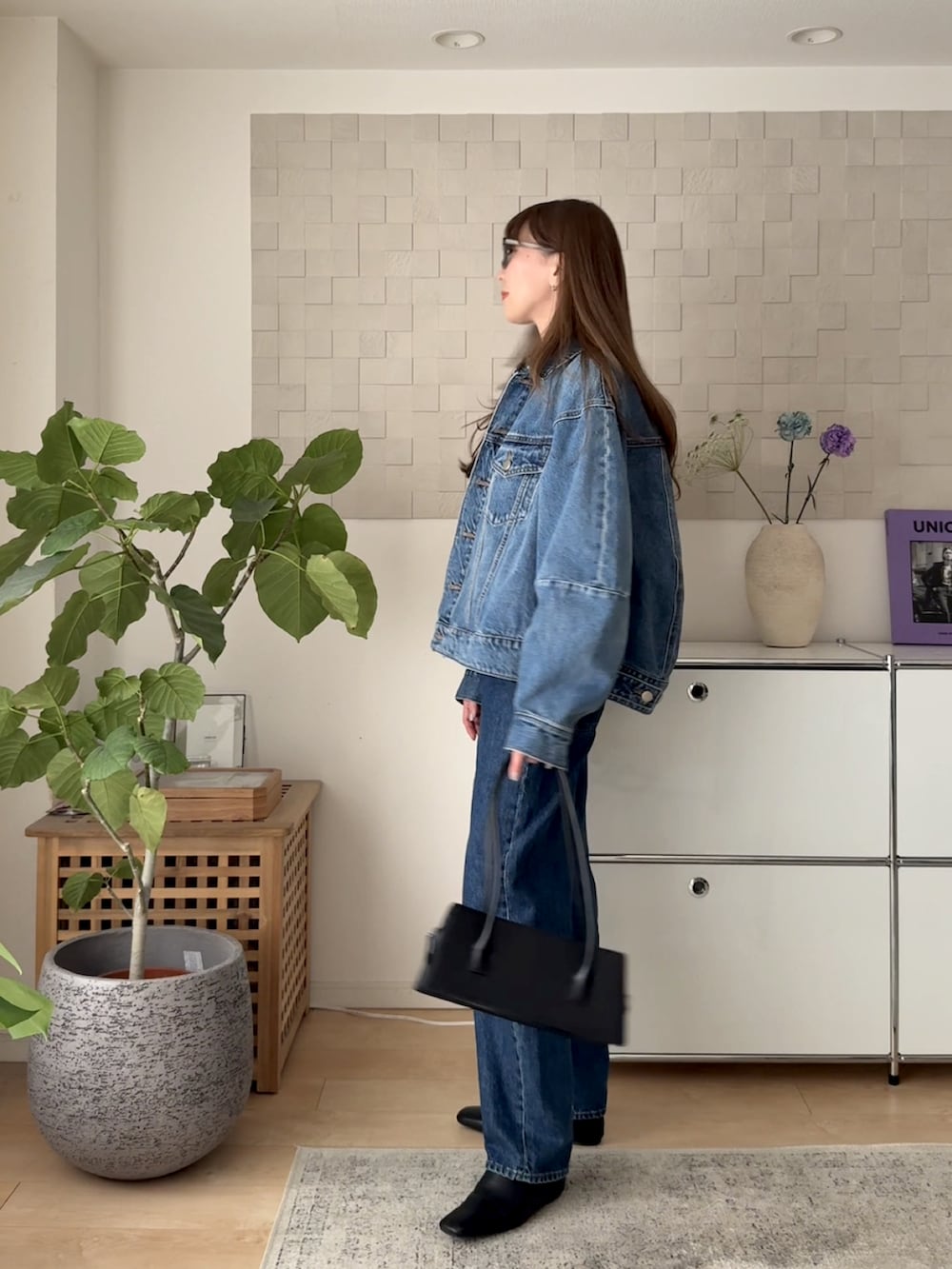 ブルー系のデニムジャケット、ブラック系のTシャツ/カットソー、ブルー系のデニムパンツを着用したレディースの春コーディネートの4枚目の写真