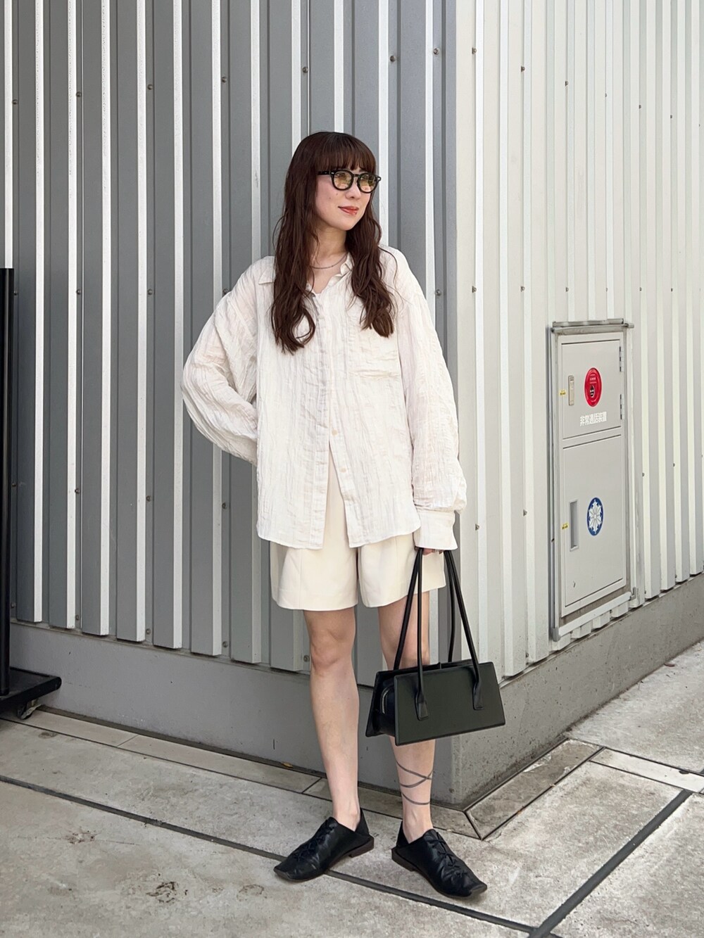 ホワイト系のシャツ/ブラウス、ホワイト系のその他パンツ、ブラック系のハンドバッグを着用したレディースの春コーディネートの2枚目の写真