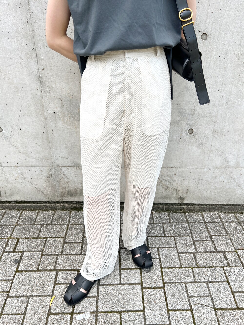 グレー系のタンクトップ、ホワイト系のその他パンツ、ブラック系のショルダーバッグを着用したレディースの夏コーディネートの5枚目の写真